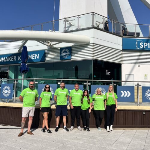 line of people in green t shirts representing rowans hospice stood in front of the spinnaker tower in portsmouth