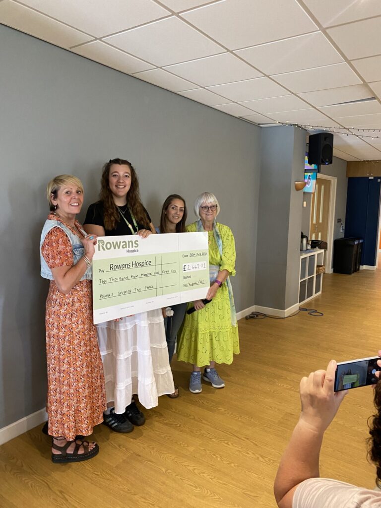 Cheque presentation at Not Forgotten Group with members of church and Rowans Hospice smiling at the camera