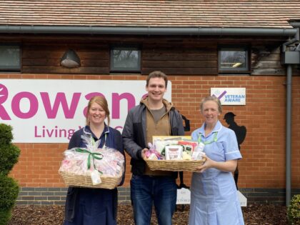 man and nurses holding a brightly coloured hamper