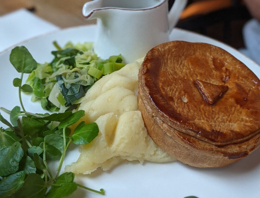 Picture of a pie over a pile of mash